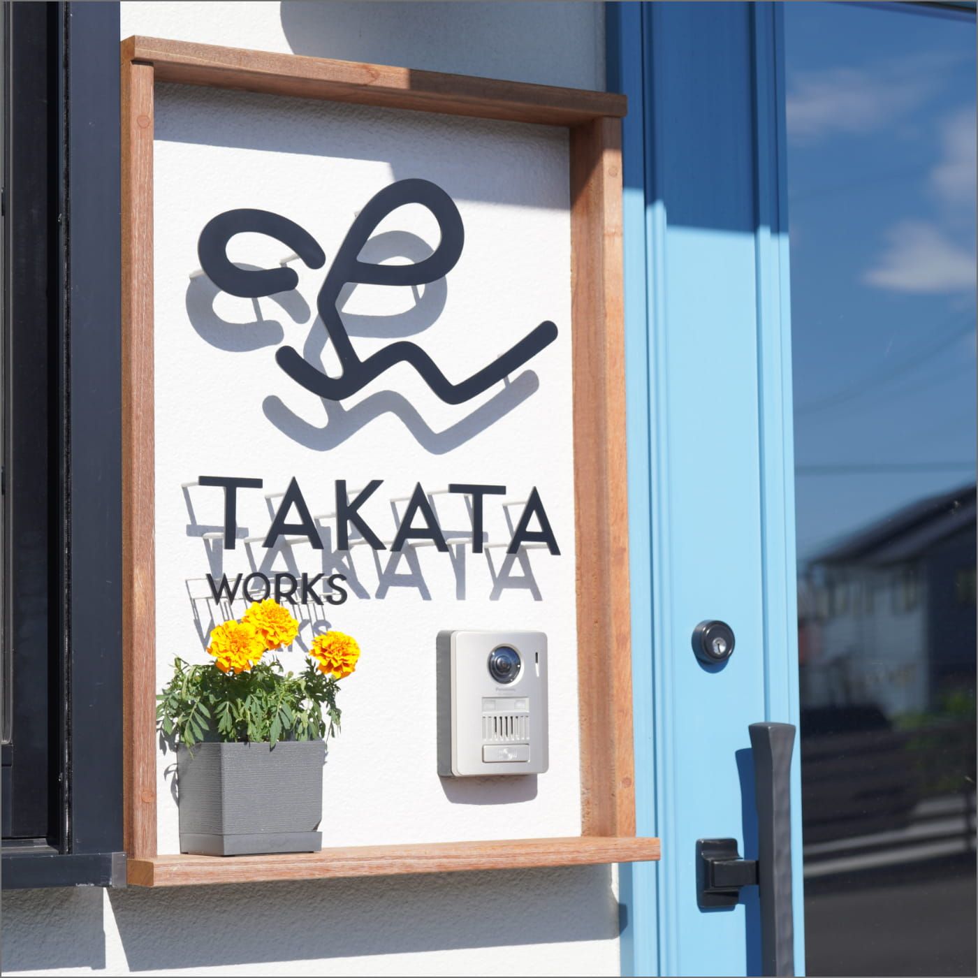 青い扉と木枠のサインが印象的なエントランス。TAKATA